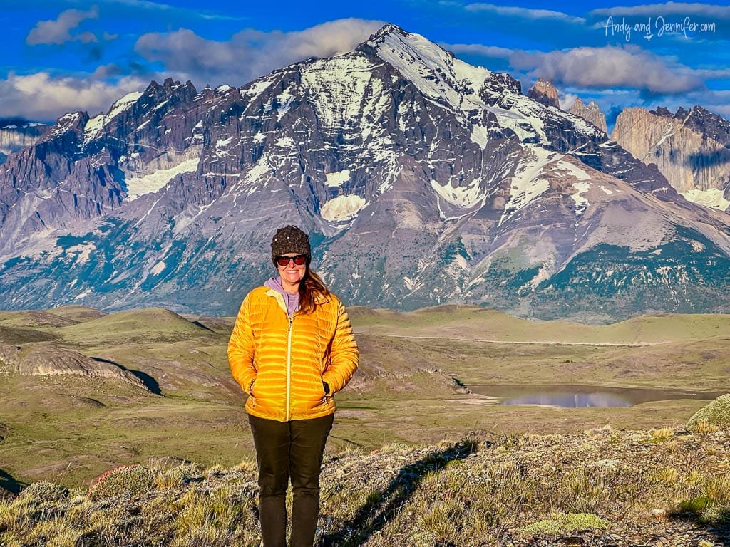 Smiling woman in yellow jacket with snowy mountains backdrop