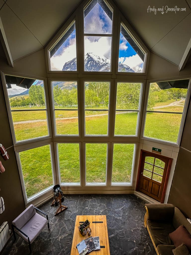 Mountain view through large living room windows with cozy seating