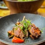 Grilled lamb chops with roasted vegetables in a rustic bowl