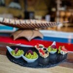 Elegant appetizers with guacamole and garnishes on slate platter
