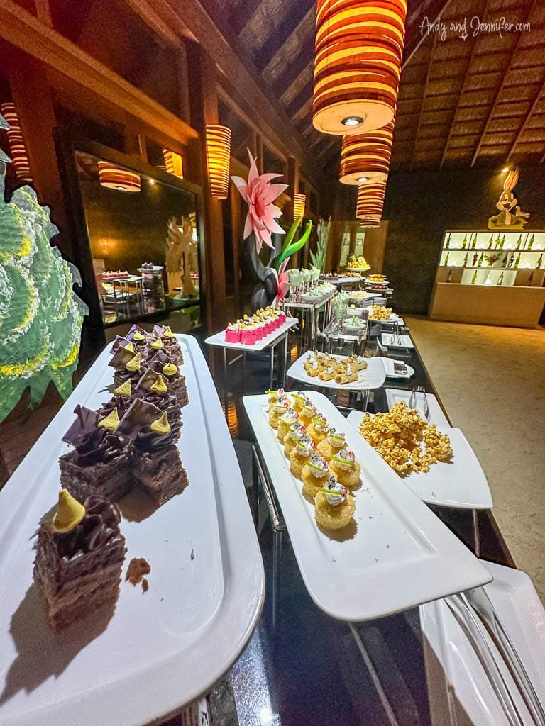 Dessert buffet with various pastries and vibrant decor.