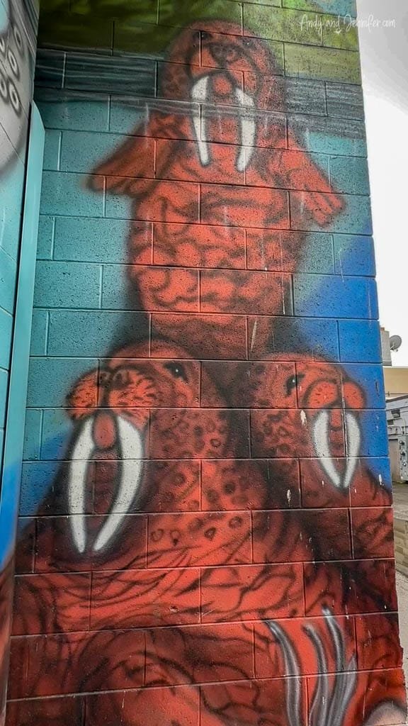 Colorful mural of three walruses stacked on a wall