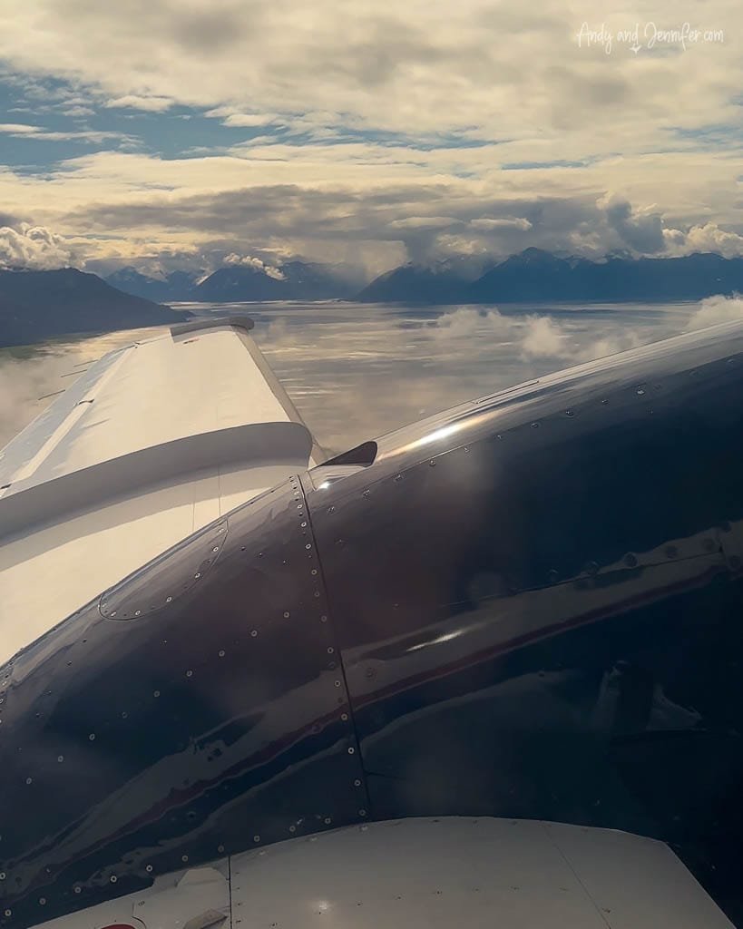View of mountains and clouds from small airplane window