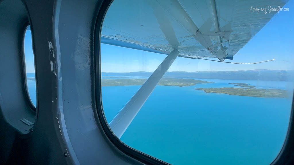 View from a plane window overlooking blue water and islands
