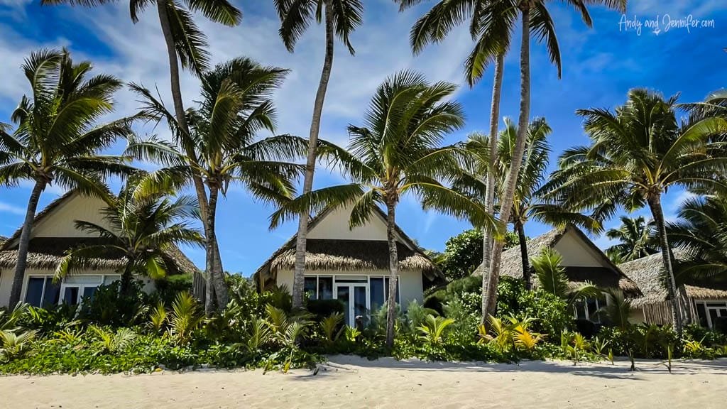 A row of charming beachfront bungalows surrounded by palm trees at the Little Polynesian Resort.