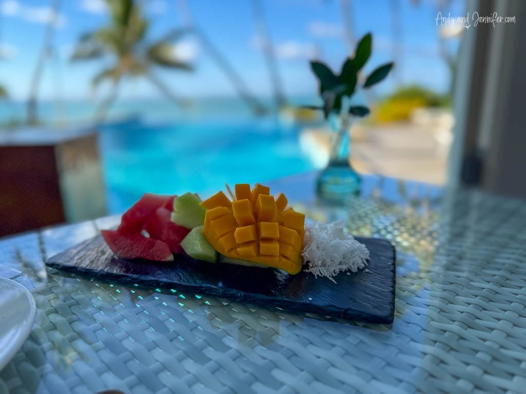 Fresh tropical fruit platter by a poolside with ocean view.