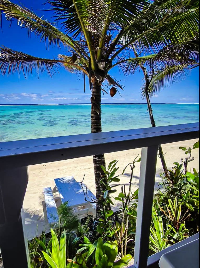 Coconut palm framing turquoise lagoon and sandy beach.