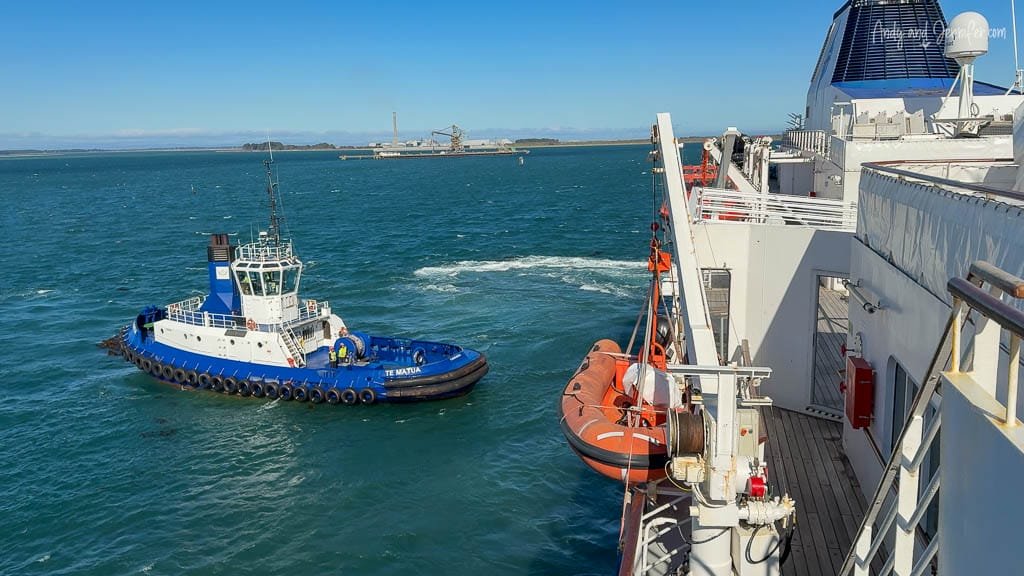 Tugboat assisting cruise ship near port terminal