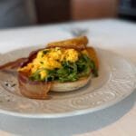 Scrambled eggs and arugula on toasted English muffin