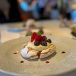 Pavlova dessert topped with berries and mint
