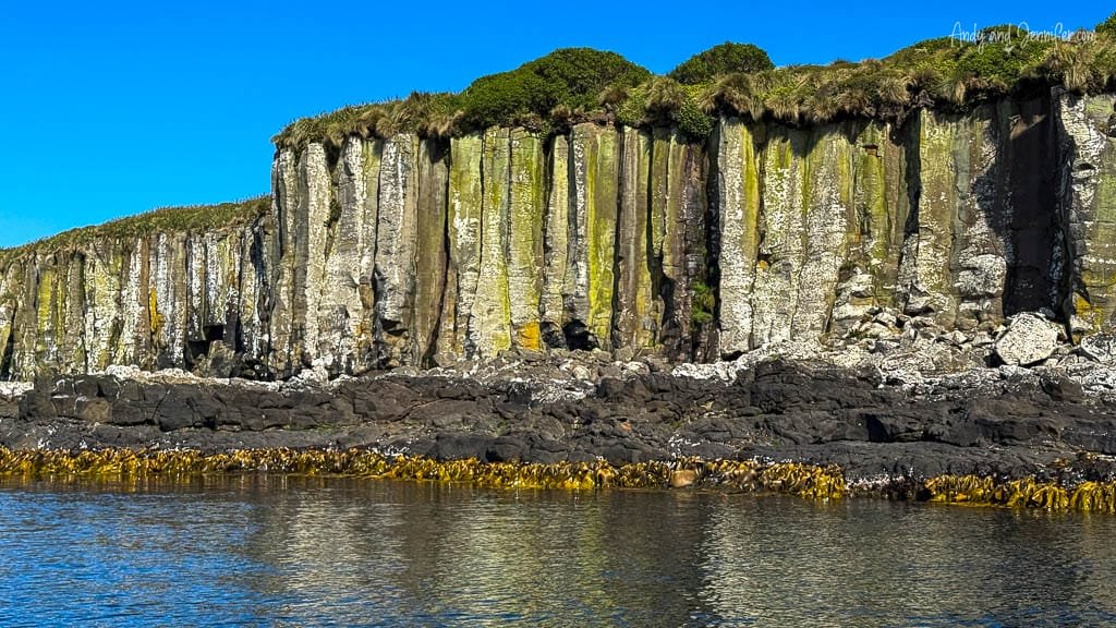 Basalt sea cliffs with green moss and clear sky
