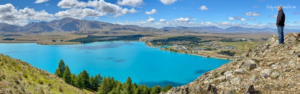 Man standing on rocky hill above Lake Tekapo