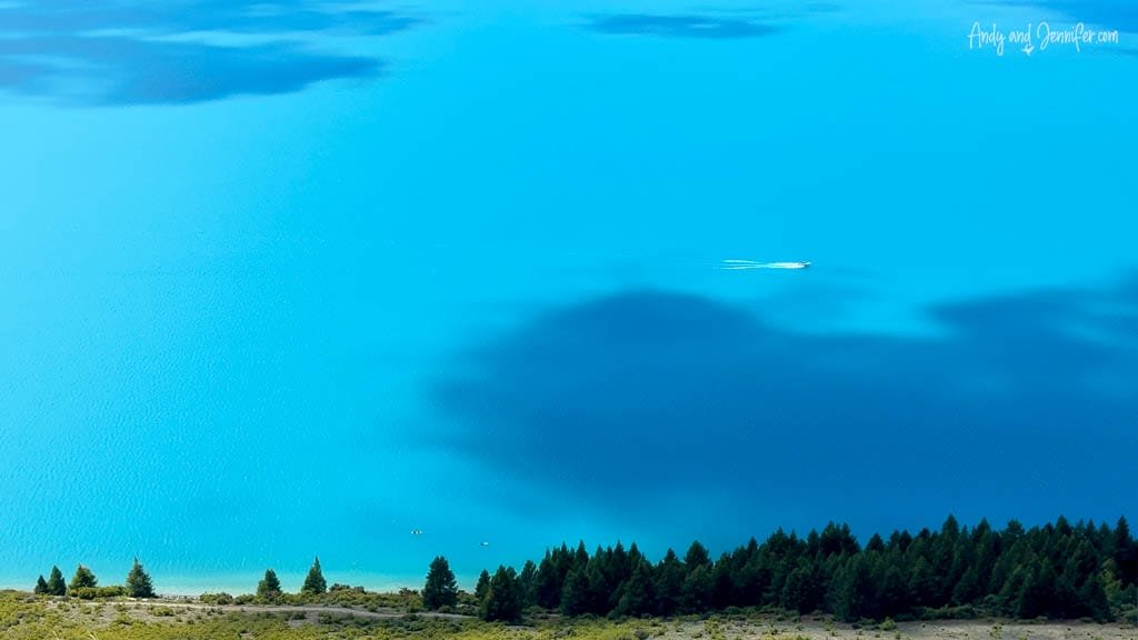 Boat crossing vivid turquoise waters of Lake Tekapo