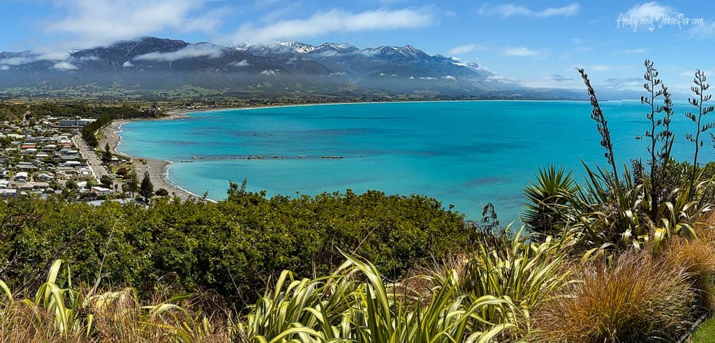Scenic coastal view of turquoise bay and snow-capped mountains