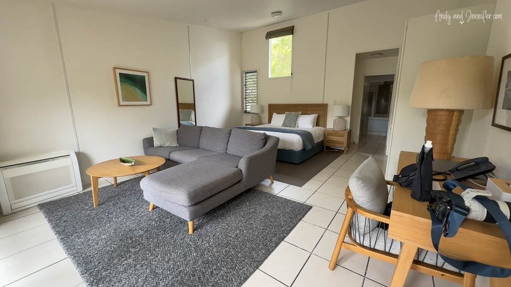 Modern hotel room with bed, sofa, and workspace
