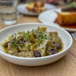 Bowl of pesto tortellini with olives and cheese