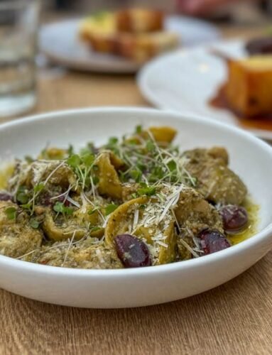 Bowl of pesto tortellini with olives and cheese