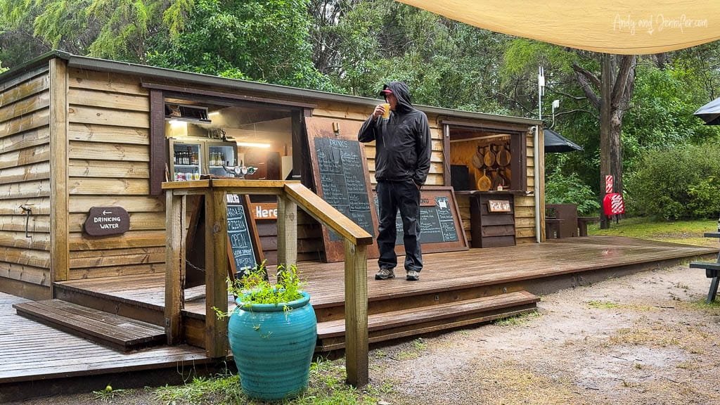 Man drinking outside rustic wooden café in forest