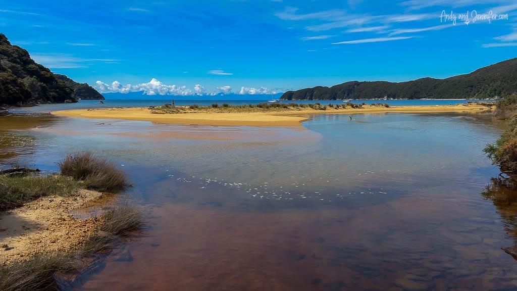 Estuary flowing to sea with sand and hills