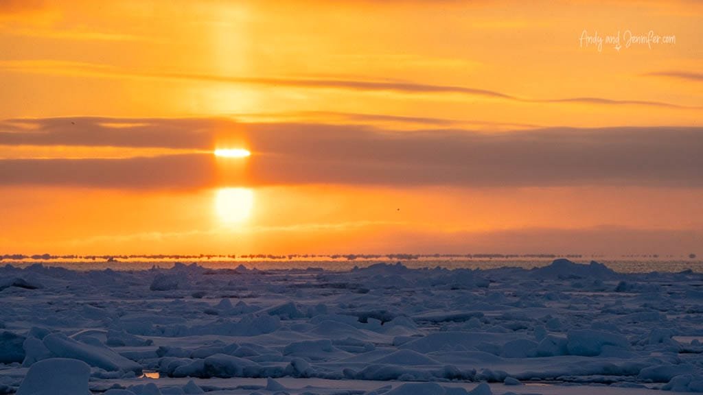 Ice-covered fjord under soft Arctic sunrise