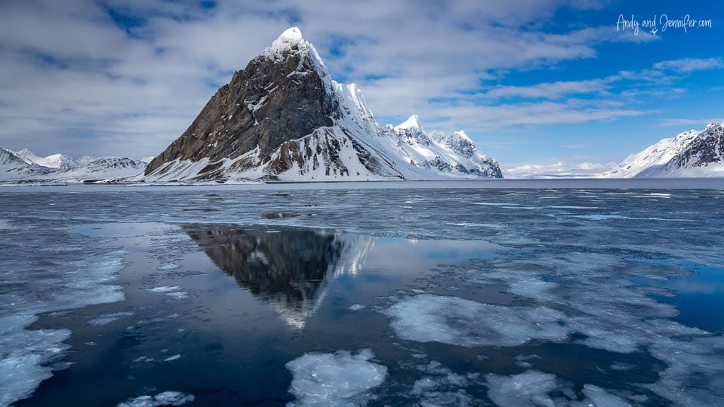 Sharp Arctic peak reflected in icy water