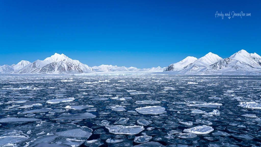 Floating ice and snowy peaks under clear sky