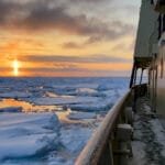 Arctic ice floes at sunset beside ship walkway