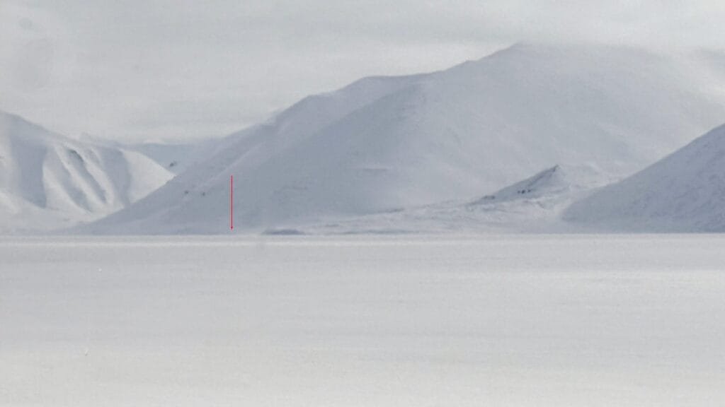 Snow-covered mountains with red arrow