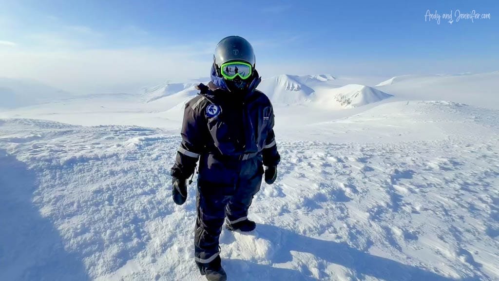 Person in winter gear standing on snowy peak