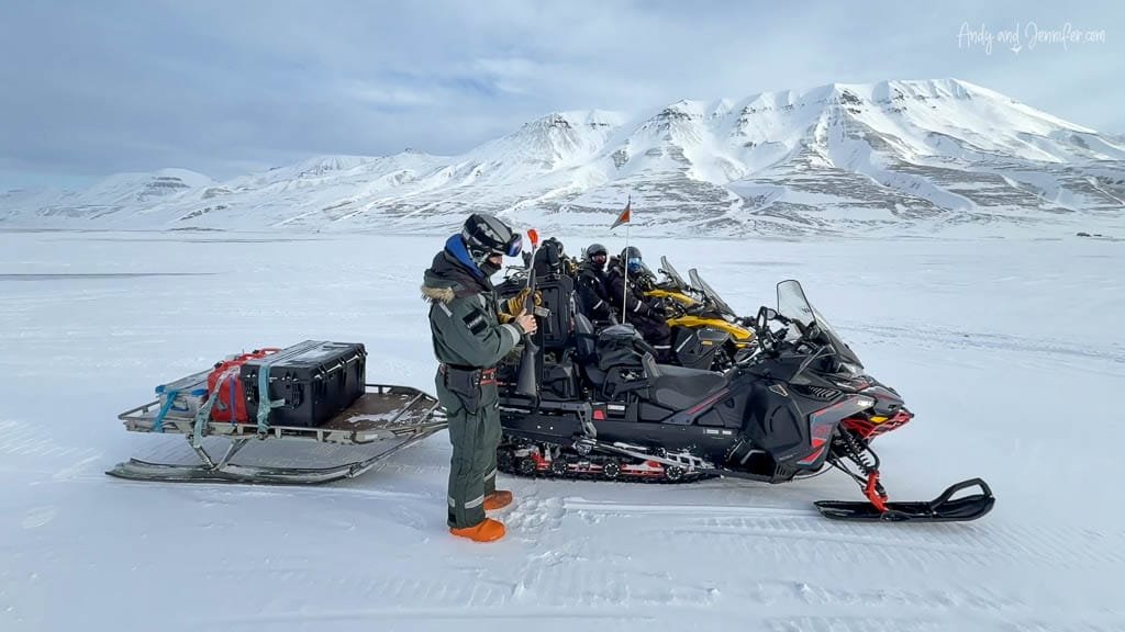 Snowmobiles and gear sled in Arctic snowfield getting ready for a snowmobile trip to East Svalbard