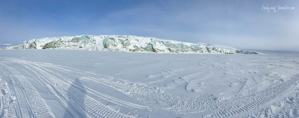 Panoramic glacier view with snowmobile tracks