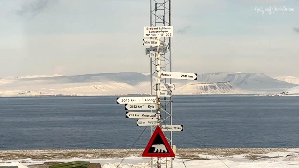 Directional signpost at Svalbard Airport near Arctic sea.