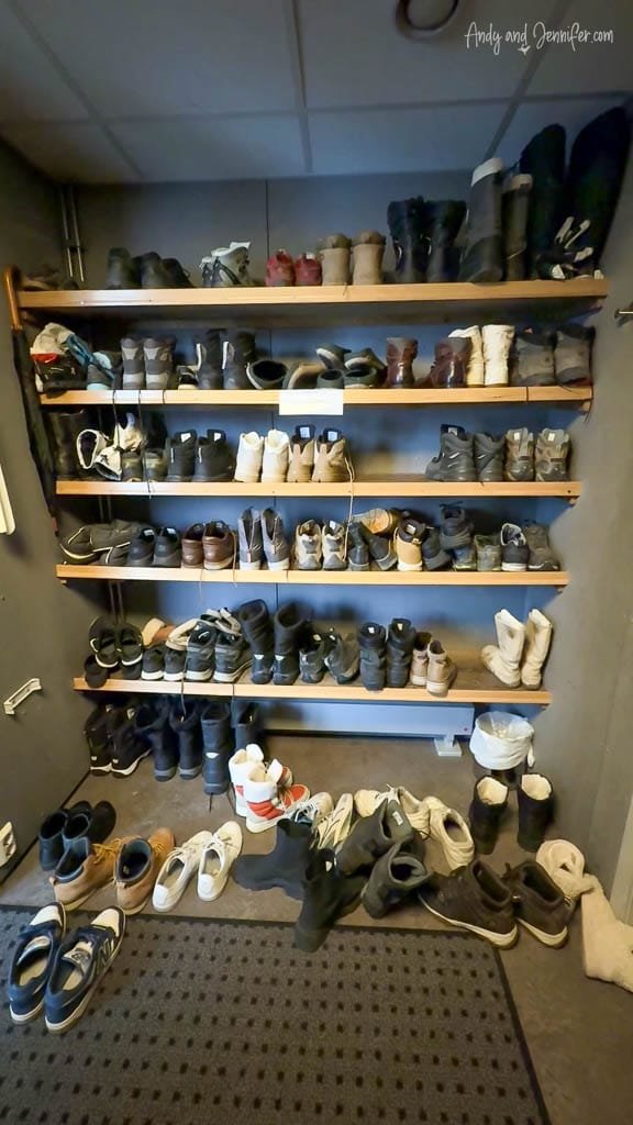 Boot rack with assorted winter footwear in hotel entryway