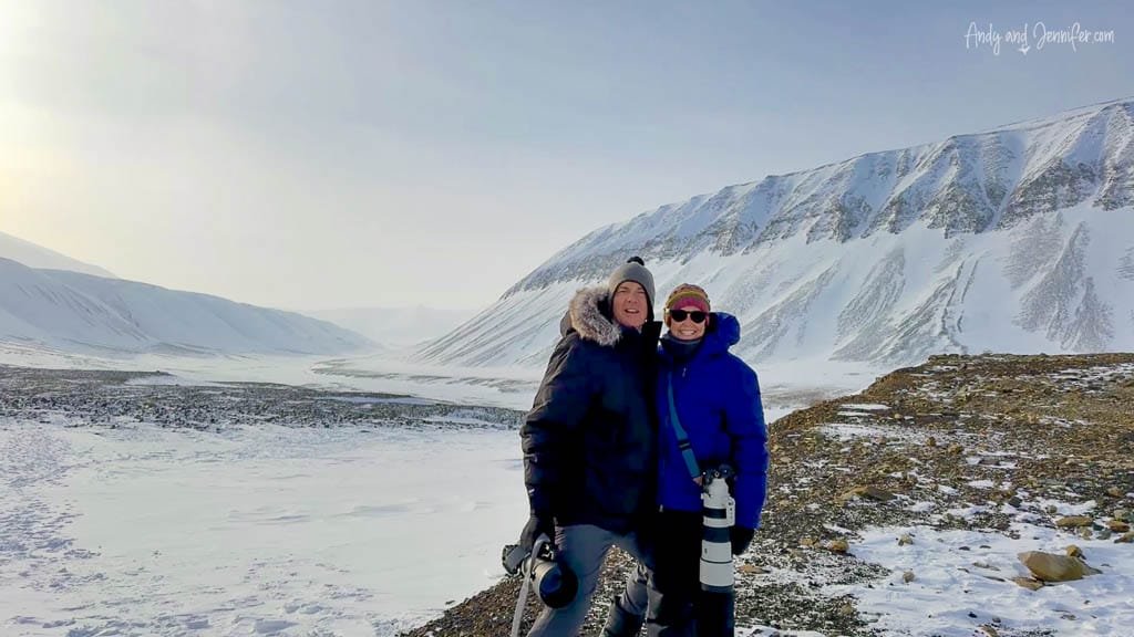 Two photographers smiling in snowy mountains