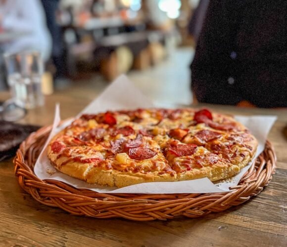 Freshly baked pepperoni pizza on rustic wooden table
