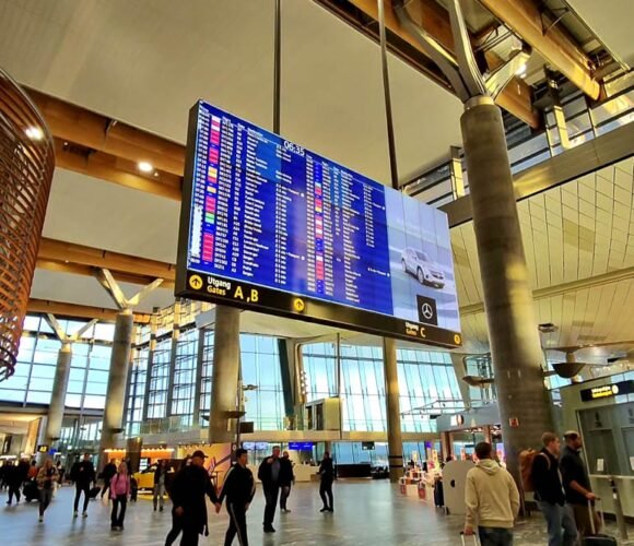 Digital flight information board in busy airport.