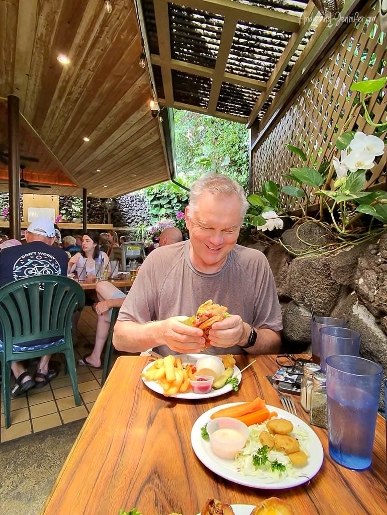 Man enjoying sandwich and fries at tropical café