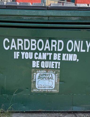 Cardboard dumpster with "Be Kind or Be Quiet" message