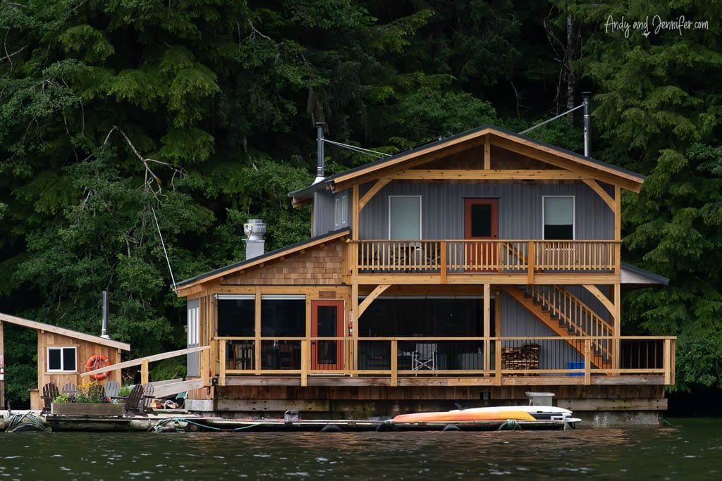 Wooden floating lodge surrounded by dense forest.