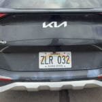 Rear view of dirty black Kia Sportage with Hawaii plate