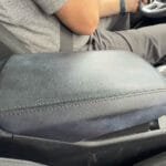 Man driving Kia with arm on dirty black center console
