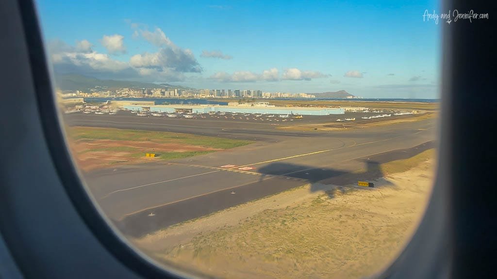 Airplane view of Honolulu airport runway and skyline