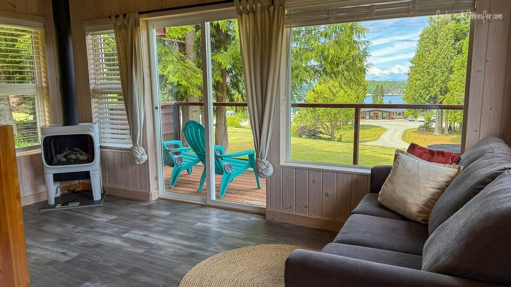 Cozy cabin living room with forest and water view