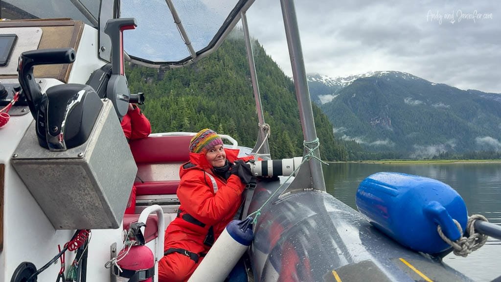Woman in red suit photographing from inflatable boat