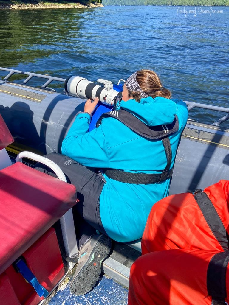 Photographer in blue jacket aiming telephoto lens