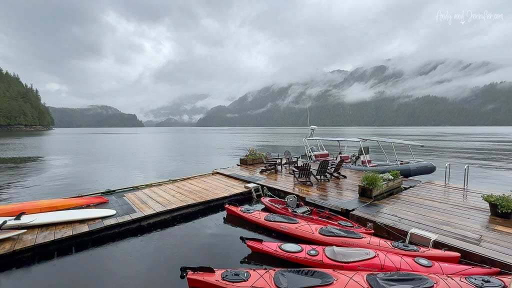 Dock with red kayaks and misty forest view