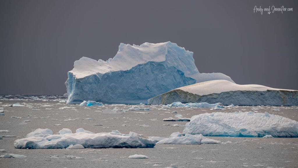 Large Antarctic icebergs floating in the Southern Ocean near the Antarctic Peninsula surrounded by sea ice and dramatic polar scenery