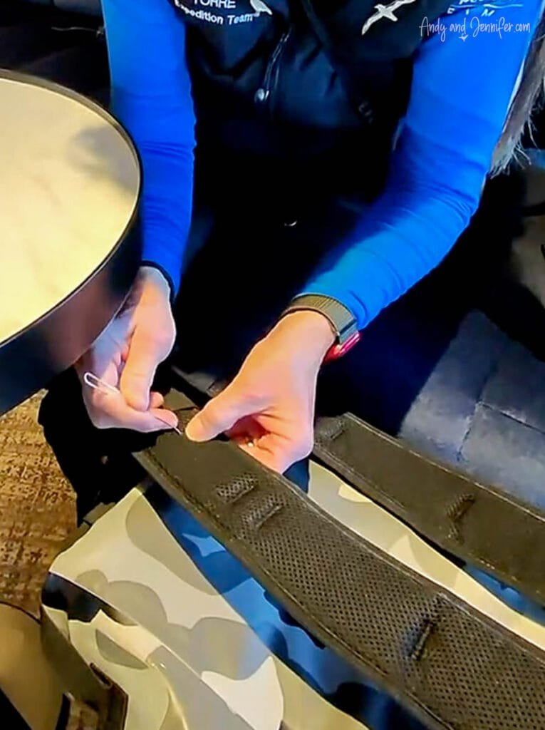 Close-up of removing debris from backpack strap as part of Antarctica biosecurity cleaning process