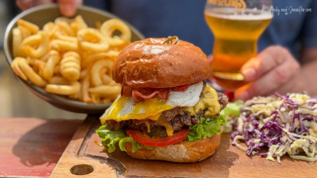 Gourmet burger with melted cheese, lettuce, tomato, and fries on the side in Akaroa, New Zealand