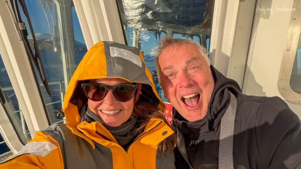 Couple smiling in heavy jackets on expedition ship deck during Antarctica voyage